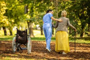 Care staff review emergency supplies and resident records beside a wheelchair in an assisted living hallway.
