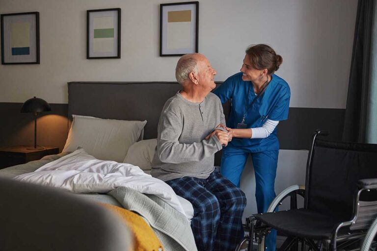 Older adult and family member reviewing medications and home safety concerns at a kitchen table.